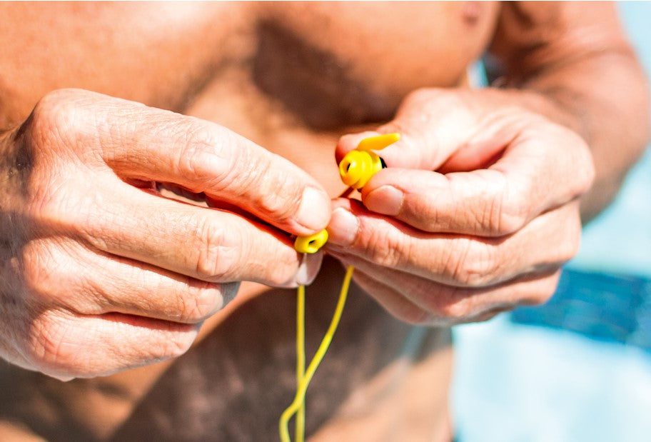 Hands holding yellow earplugs