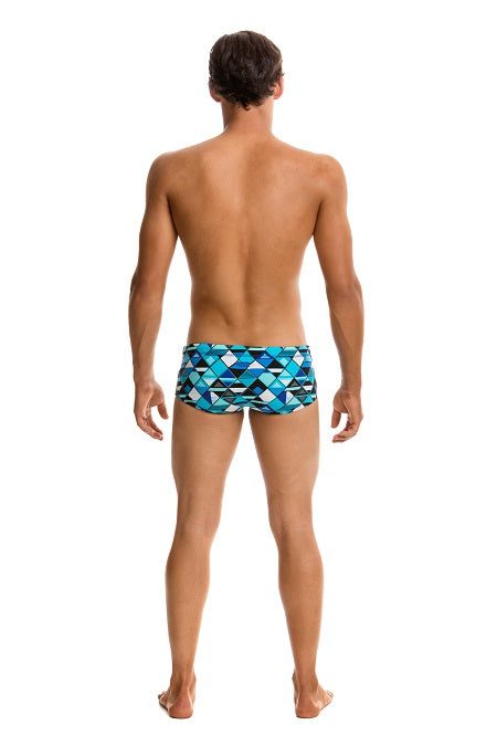 Person wearing blue geometric swim briefs, back view